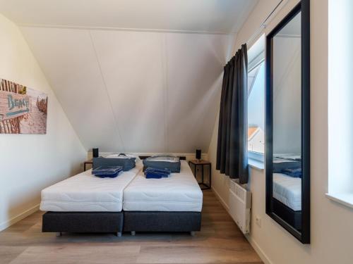 twee bedden in een kleine kamer met een raam bij Nice holiday home with sauna near a lake in Simonshaven