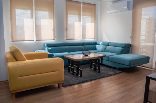 a living room with a blue couch and a table at Allure 23 in Gevgelija