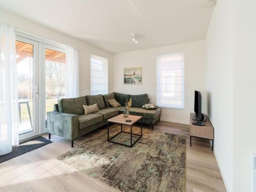 a living room with a couch and a tv at Nice holiday home with sauna near a lake in Simonshaven