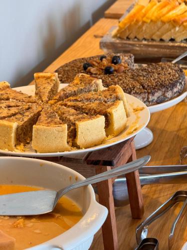 Hotel Caitá في مورو دي ساو باولو: طاولة عليها ثلاثة أطباق من الخبز والحلويات الأخرى