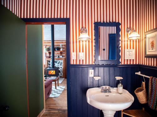 y baño con lavabo y espejo. en Chalet “Lendemain de ville” avec accès au lac, en Saint Adolphe D'Howard