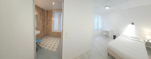 a white bathroom with a shower and a bed at Hotel C&Ouml;RONA Lourdes in Lourdes