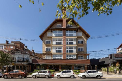 un edificio con coches estacionados frente a él en LOCAR-IN GRAMADO Residencial Garibaldi Centro, en Gramado