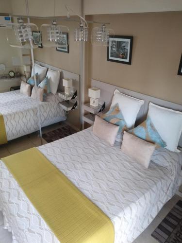 ein Schlafzimmer mit zwei Betten mit Kissen in der Unterkunft Bello Departamento 2 Habitaciones, Barrio Norte in San Miguel de Tucumán