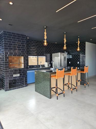 a large kitchen with orange chairs and a counter at Casa de Alto Padrão na Represa de Avaré in Paranapanema