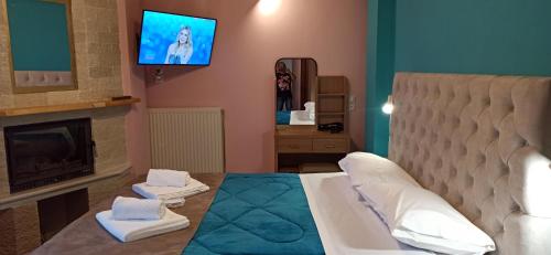 salon z łóżkiem i telewizorem na ścianie w obiekcie tokastro w mieście Arachova