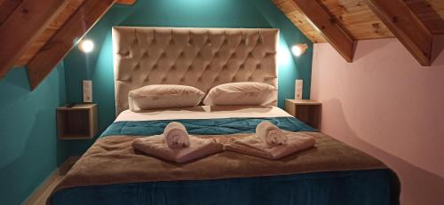 ein Schlafzimmer mit einem großen Bett mit zwei Handtüchern darauf in der Unterkunft tokastro in Arachova