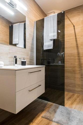a bathroom with a shower and a sink and a mirror at Spadzista 2 in Kłodzko