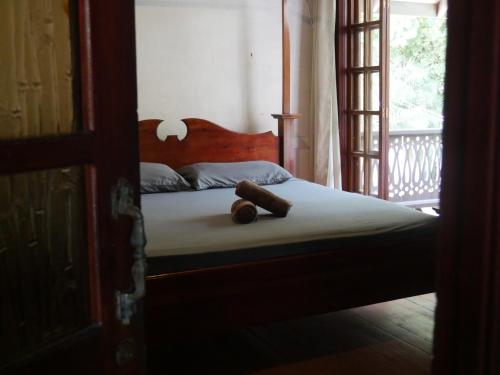 a bedroom with a bed with a wooden headboard and a window at Hotel Mandacarú Puerto Viejo in Puerto Viejo