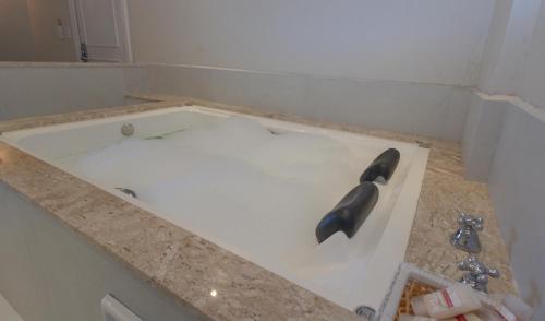 a bathtub being remodeled with a black nozzle at Lizon Curitiba Hotel in Curitiba