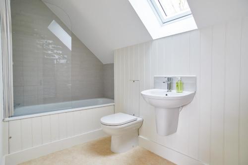 a white bathroom with a toilet and a sink at PigLets in Castle Acre