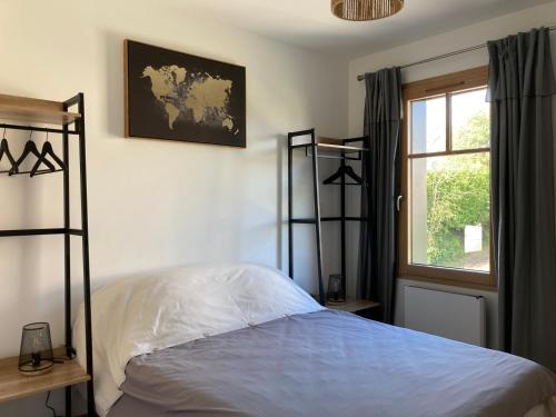 Schlafzimmer mit einem Bett und einem Fenster in der Unterkunft Gîtes des Guettes in Saint-Suliac