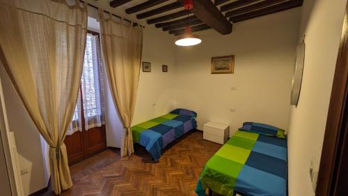 a bedroom with two beds and a window at Borgo Antico in Gubbio