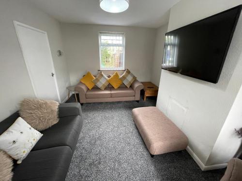 een woonkamer met een bank en een flatscreen-tv bij LEAVESLEY rd in Blackpool