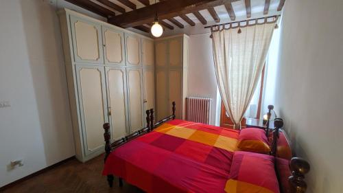 a bedroom with a bed with a colorful blanket at Borgo Antico in Gubbio