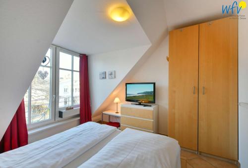 Schlafzimmer im Dachgeschoss mit einem Bett und einem TV in der Unterkunft Villa Vogelsang Ferienwohnung 12 in Binz
