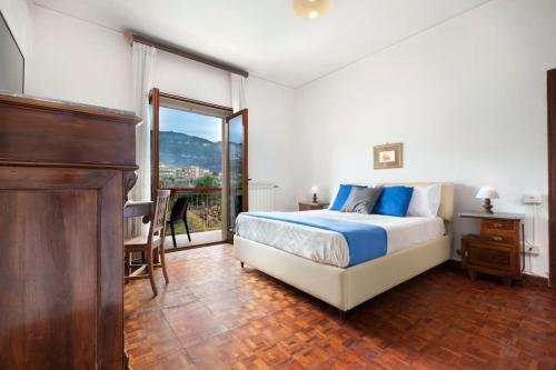 a bedroom with a bed and a table and a window at Maison Alessia - Around Sorrento in Sorrento