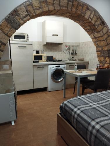uma cozinha com um lavatório e uma mesa num quarto em La casetta di Patry em Tarquinia