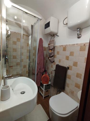 ein Badezimmer mit einem weißen Waschbecken und einem WC in der Unterkunft La casetta di Patry in Tarquinia