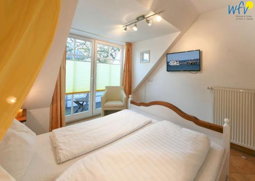 ein Schlafzimmer mit einem Bett, einem Stuhl und einem Fenster in der Unterkunft Villa Vogelsang Ferienwohnung 11 in Binz