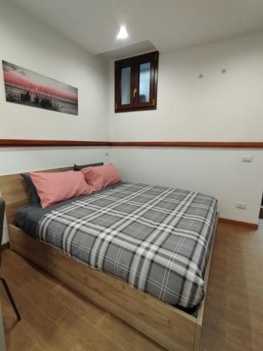 a bedroom with a bed with a plaid blanket at La casetta di Patry in Tarquinia