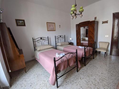 Un dormitorio con dos camas y un espejo y una silla. en Casa Vacanze Farinella, en Putignano