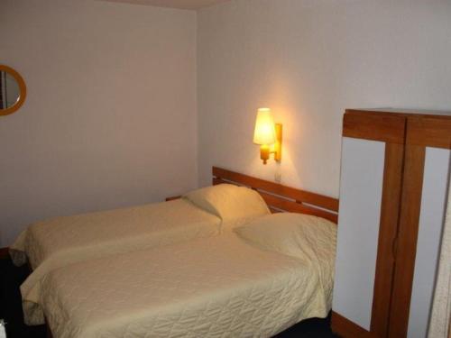 ティーニュにあるAppartement Tignes, 2 pièces, 4 personnes - FR-1-449-88のベッドルーム1室(ベッド2台付)、壁に照明が備わります。