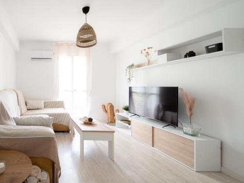 ein weißes Wohnzimmer mit einem Flachbild-TV in der Unterkunft Luxury Home Mezquita in Córdoba