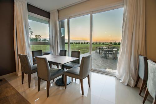 Un comedor con mesa y sillas y una gran ventana. en Hotel Bel Posto by Tandem, en Realicó