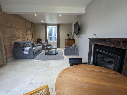 a living room with a couch and a fireplace at Gîte familial rénové avec piscine, jardin de 1 hectare et vélos à disposition, situé en pleine campagne - FR-1-591-579 in Tilly