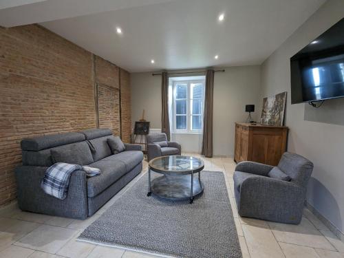 a living room with two couches and a tv at Gîte familial rénové avec piscine, jardin de 1 hectare et vélos à disposition, situé en pleine campagne - FR-1-591-579 in Tilly