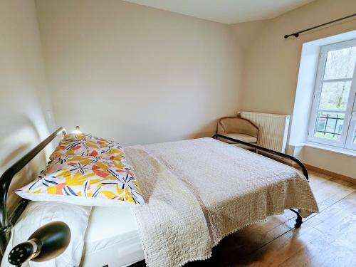 a bedroom with a bed with a pillow and a window at Gîte familial rénové avec piscine, jardin de 1 hectare et vélos à disposition, situé en pleine campagne - FR-1-591-579 in Tilly