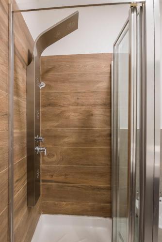 a shower with a wooden door in a bathroom at Hotel Bel Posto by Tandem in Realicó