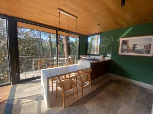 una cucina con pareti verdi e tavolo e sedie di Desnivel a Valle de Bravo