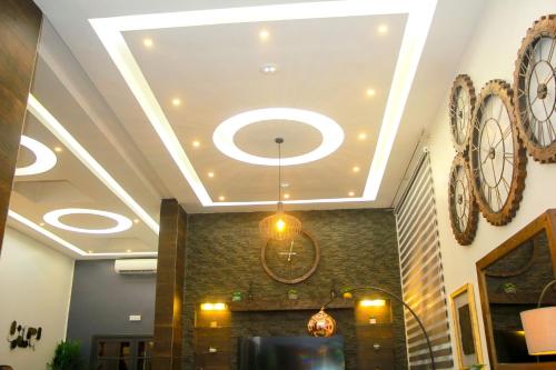 a lobby with a chandelier and clocks on the ceiling at VIILA LibDo in Cococodji