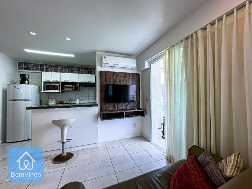 a living room with a kitchen with a refrigerator at Apartamento ao lado do Salvador Shopping 3 in Salvador