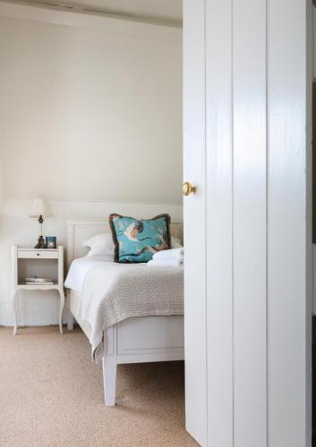 a bedroom with a white bed with a blue pillow at Shelbourne Georgian Townhouse in Kenmare