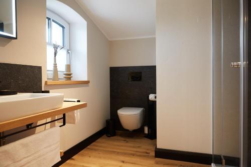 La salle de bains est pourvue d'un lavabo blanc et de toilettes. dans l'établissement Binnendiek Haus 6 Comfort-Apartment 10, à Büsum