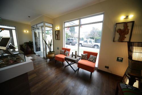 a living room with orange chairs and a table at Hotel Boutique Reyall in Santiago