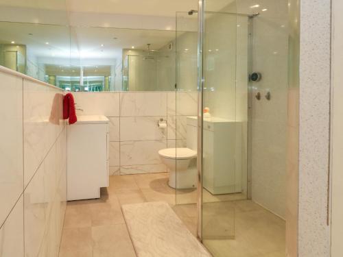 La salle de bains est pourvue de toilettes et d'une douche en verre. dans l'établissement Chickerell House, à Weymouth