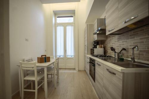 a kitchen with a sink and a table with a counter at Luxury apartment in Naples in Naples