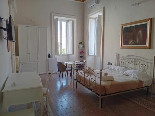 a bedroom with a bed and a dining room with a table at iLCastellano - Suites & Apartments in Lecce
