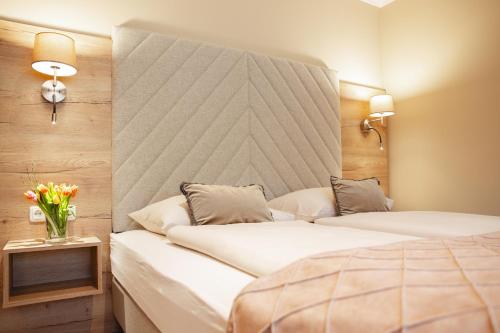 a hotel room with two beds and a headboard at Hotel Krone in Mondsee