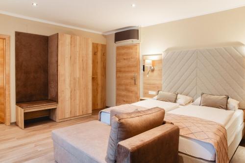 a hotel room with two beds and a couch at Hotel Krone in Mondsee