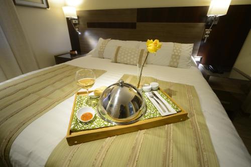 a tray with a plate of food on a bed at Hotel Boutique Reyall in Santiago