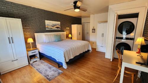 1 dormitorio con cama y pared de ladrillo en Watercolors Retreat on Crooked Lake, en Conway