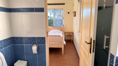 a bathroom with a toilet and a small bedroom at Villa with beautiful sea views, pool & spacious gardens & great for remote work in Ferragudo