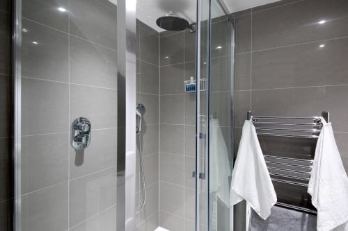 La salle de bains est pourvue d'une cabine de douche avec une porte en verre. dans l'établissement Sheen's House, à Édimbourg