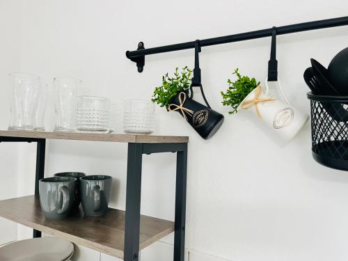 a shelf with jars and vases on a wall at LENASTAY I Modernes Apartment-Studio near Uni in Kaiserslautern