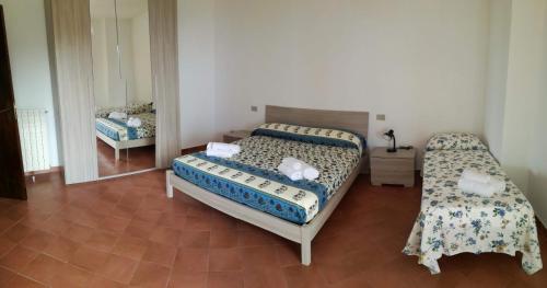 a bedroom with two beds and a mirror at Grecale in Centola